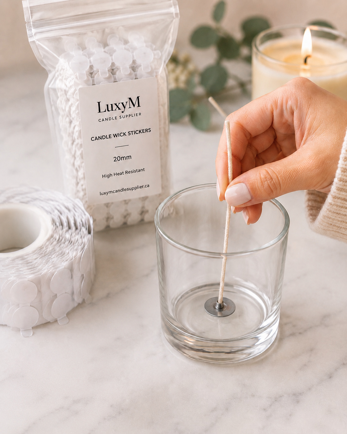 Applying premium 20mm high heat resistant candle wick stickers to secure a cotton wick in a glass candle jar for candle making.